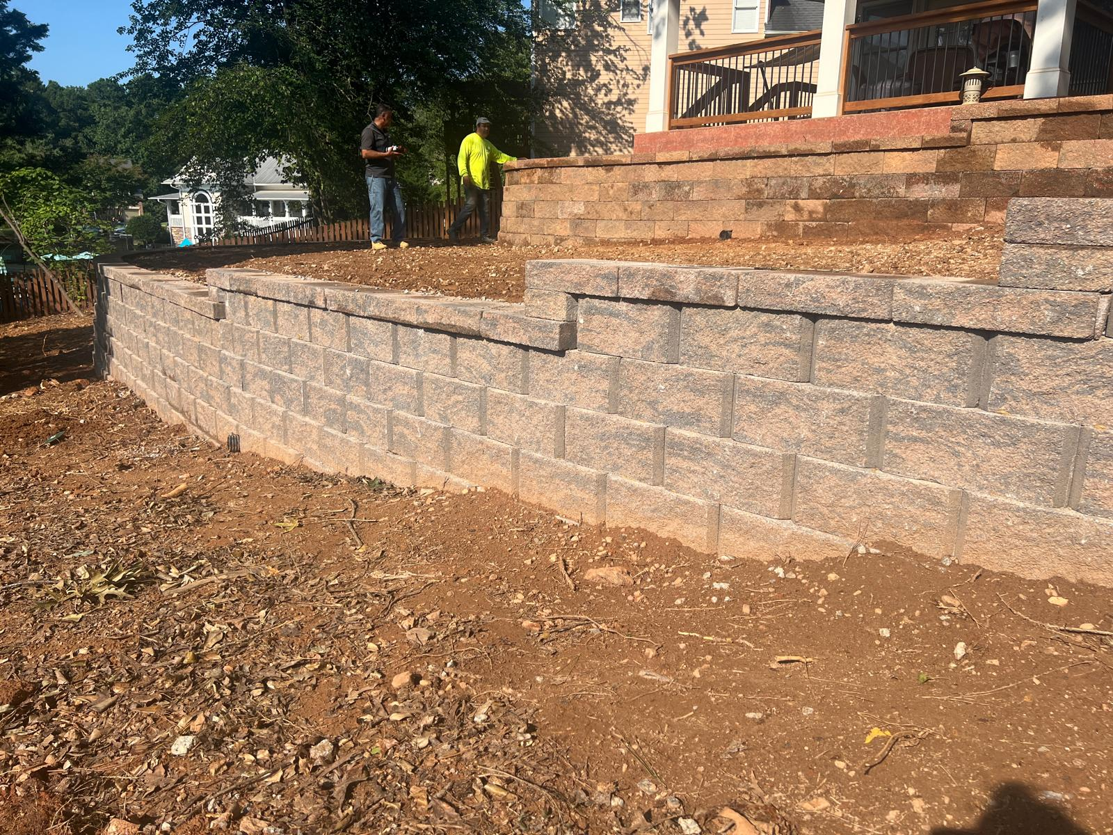 Structural retaining wall holding sloped yard soil securely