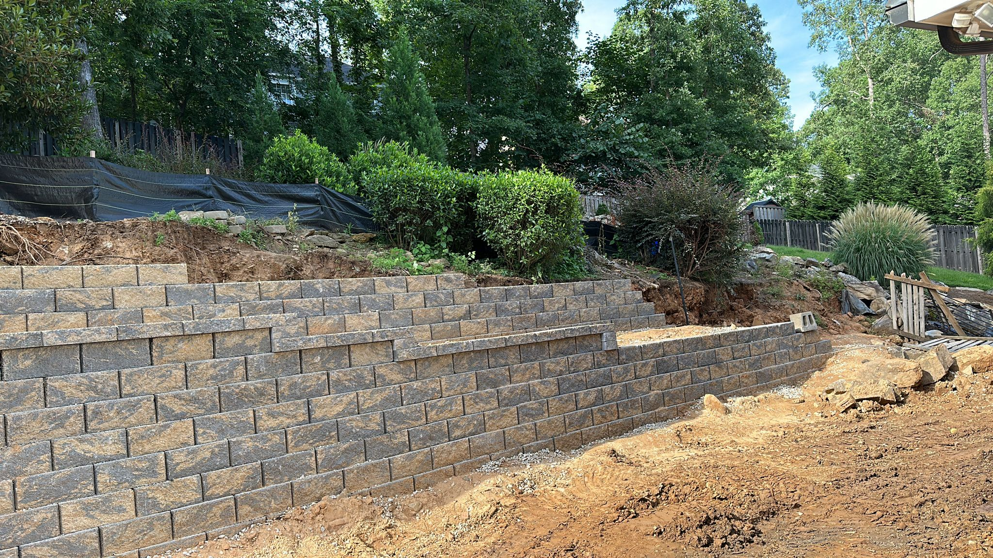Curved retaining wall protecting home perimeter from runoff